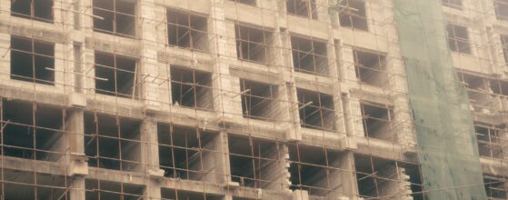 Unfinished commercial building under construction with scaffolding and exposed structural framing