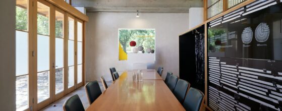 Modern conference room with long wooden table and chairs for meetings
