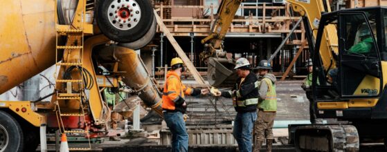 Two construction workers reviewing plans at an active construction site in Seattle