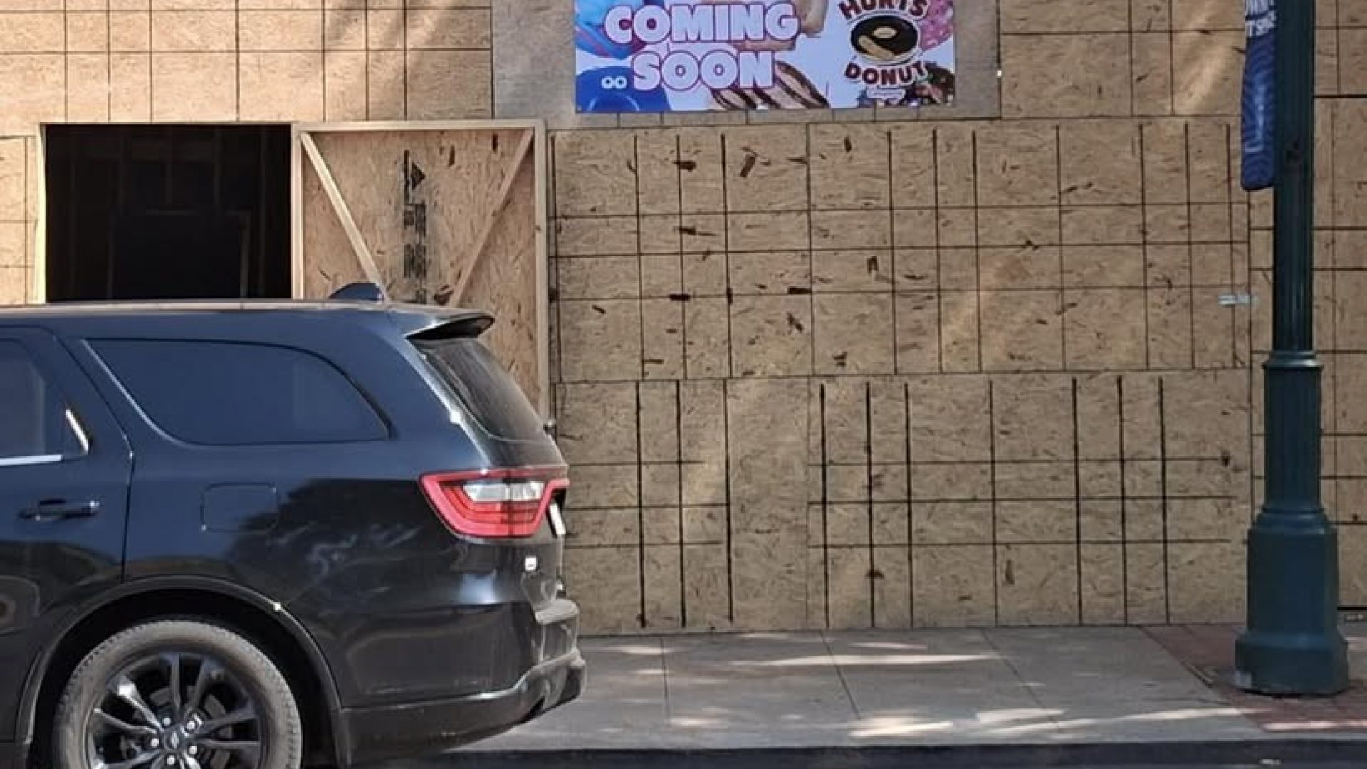 Plywood-covered storefront of future Hurts Donut in Hot Springs, AR under construction