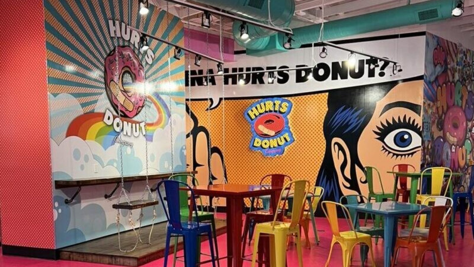Interior seating area of Hurts Donut in Hot Springs, AR with pop-art murals