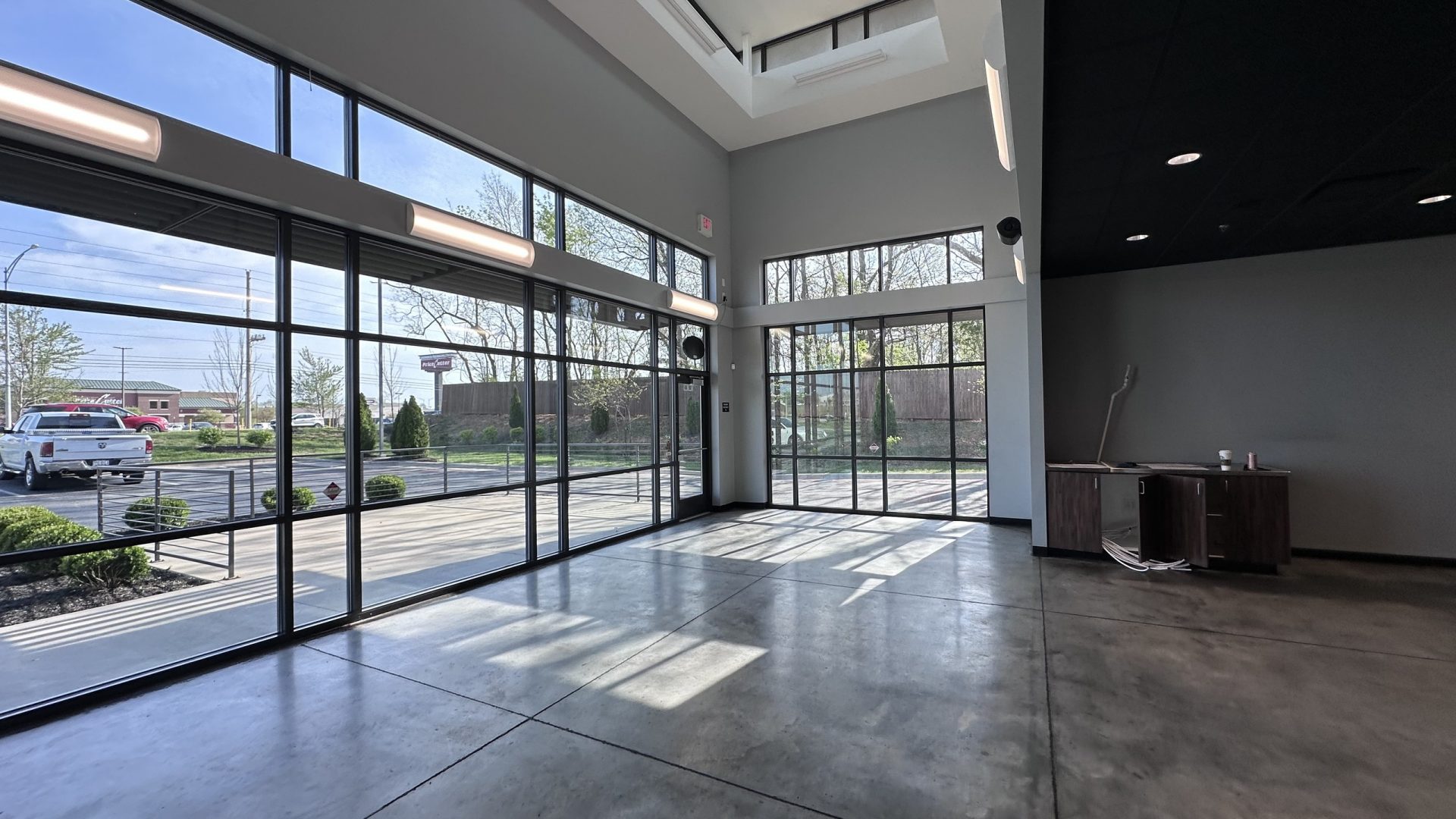 Empty interior of a Springfield MO restaurant space with tall storefront windows and concrete floors