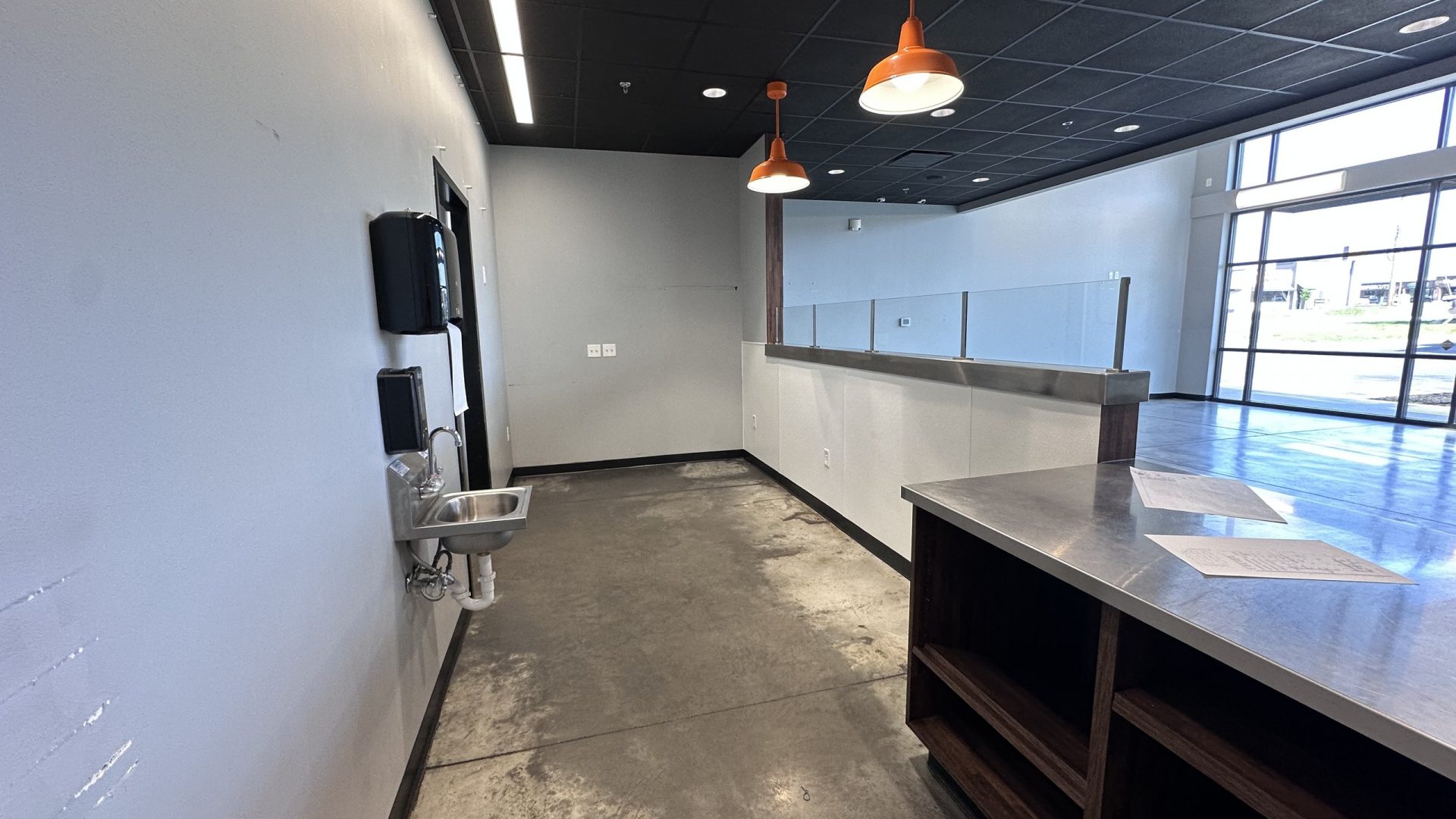 Unfinished interior of a Pancheros Mexican Grill dining area with orange pendant lights
