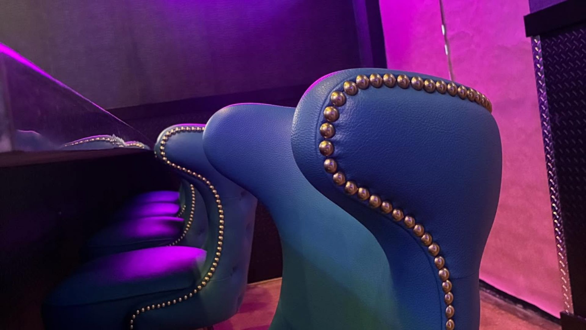 Teal leather bar stools and neon sign inside Rock N Roll Sushi, Oxford, MS